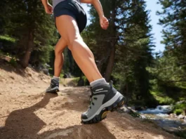 A female hiker confidently strides on a mountain trail, showcasing well-fitted women's hiking boots for optimal fit and comfort on a hike.