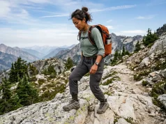 Best Women’s Hiking Boots for Every Foot Shape Woman in Merrell hiking boots descending a rocky mountain trail with a loaded daypack
