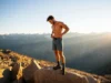 Men’s Hiking Shorts: A Data-Backed Analysis A hiker stands on a mountain peak, looking down at his technical men's hiking shorts, representing a data-backed analysis of the best gear for the trail.