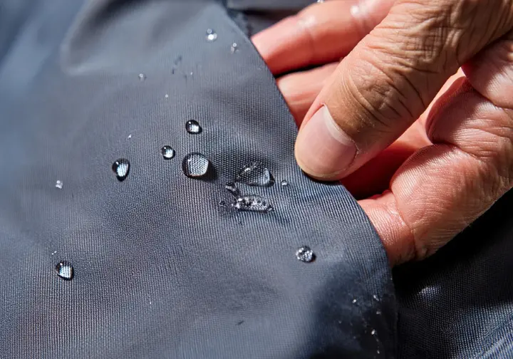 A close-up view of water beading on the technical fabric of men's hiking shorts, illustrating the fundamental properties of quality hiking gear.
