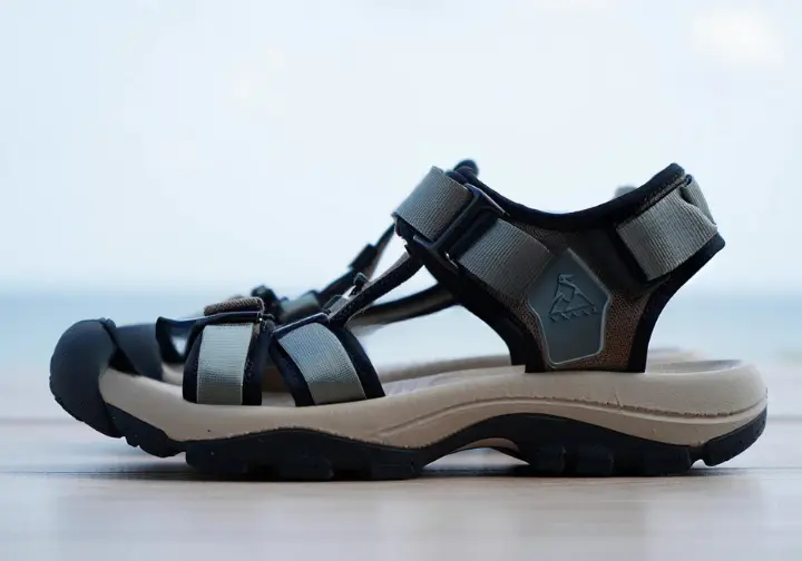 Close-up of a women's hiking sandal with an overlay indicating heel-to-toe drop measurement, providing a biomechanical primer.