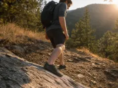 Barefoot Hiking Shoes Buying Guide for Real Trail Hiker in barefoot hiking shoes stepping down a rocky trail section