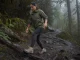 Best Women’s Waterproof Shoes (And When to Skip Them) Woman in waterproof hiking shoes stepping across a wet muddy trail on an overcast morning