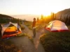 Blacktail vs Tungsten: A Field-Tested Hiker’s Verdict A hiker stands at a fork in a mountain trail at sunset, deciding between a lightweight Marmot Tungsten tent and a durable Big Agnes Blacktail tent pitched on separate paths.
