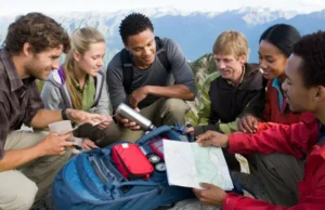 The Hiking Checklist: The 10 Essentials & More Hikers meticulously checking their gear, embodying the hiking checklist and the 10 essentials for a safe outdoor adventure.