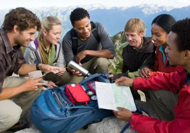 Hikers meticulously checking their gear, embodying the hiking checklist and the 10 essentials for a safe outdoor adventure.