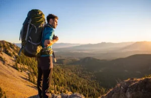 Find Your Perfect Hiker’s Backpack: A Data-Backed Guide A hiker with a perfectly fitted backpack stands on a mountain summit at sunset, looking out over a vast valley.