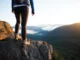 Women’s Waterproof Shoes: A Field-Tested Trail Guide A woman hiker in waterproof shoes stands on a misty mountain trail, representing a field-tested guide to women's waterproof hiking footwear.