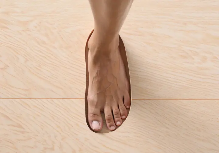A top-down view showing a foot inside a flexible barefoot hiking shoe, highlighting the wide toe box that allows the toes to splay naturally.