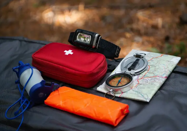 A collection of hiking gear laid out on a tarp, representing the Ten Essential Systems to bring on every hike.