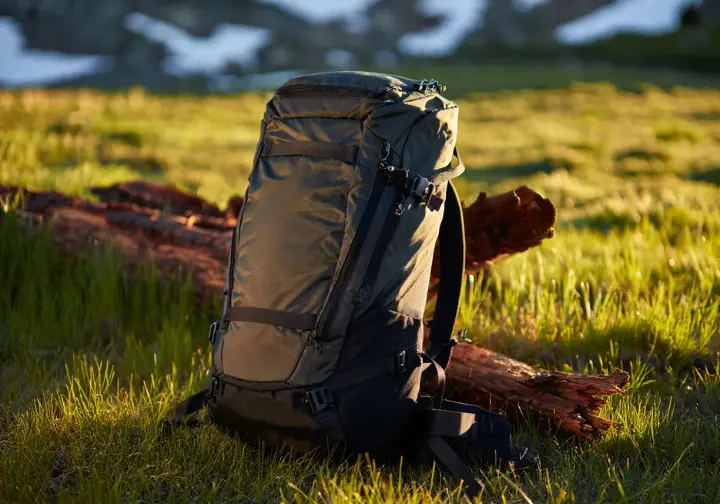 A top-rated hiker's backpack for 2025 is displayed professionally in a beautiful mountain meadow.