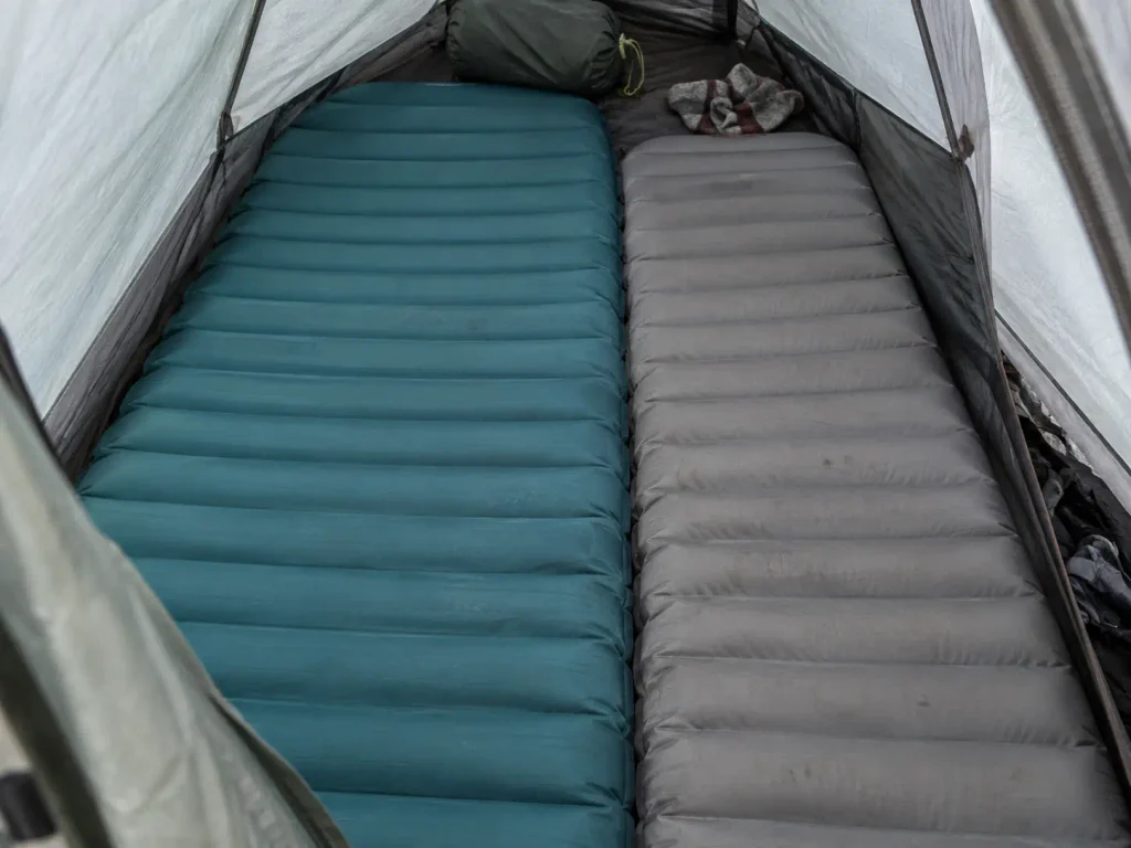 Two sleeping pads side by side inside a 2 person backpacking tent showing how little floor room is left