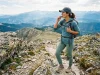 Best CamelBak Hydration Backpack for Every Hike Hiker drinking from a CamelBak hydration backpack hose on a sunlit ridgeline trail