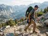 How to Pick a Hiking Backpack That Actually Fits Hiker on an alpine trail wearing a loaded hiking backpack with a properly set hip belt