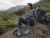 Best Backpacking Shoes That Won’t Bottom Out at Mile 10 Hiker resting at a switchback in backpacking shoes with a loaded pack beside her
