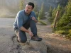 Why Most Walking Sneakers for Hiking Are Road Shoes Hiker lacing a low-cut Merrell Moab Speed walking sneaker at the edge of a dirt trail
