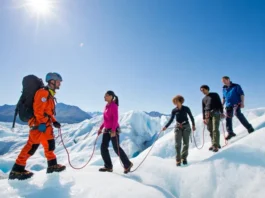 Diverse group of hikers on the Matanuska Glacier, led by a professional guide, illustrating the guided tour experience versus a self-guided walk.