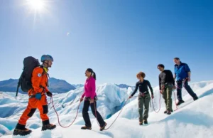 Matanuska Glacier: Guided Tour vs. Self-Guided Walk Diverse group of hikers on the Matanuska Glacier, led by a professional guide, illustrating the guided tour experience versus a self-guided walk.