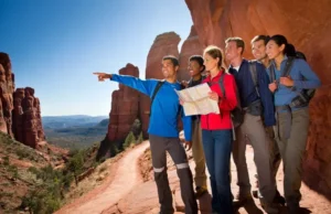Sedona’s Best Hikes: A Trail Guide for Every Hiker Diverse hikers on a panoramic Sedona red rock overlook with trails visible below, symbolizing a comprehensive trail guide to Sedona's best hikes.