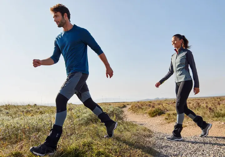 Diverse hikers wearing gaiters navigate varied trail conditions, demonstrating the key benefits of hiking with gaiters for protection and comfort.