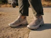 Best Stylish Hiking Shoes That Still Grip the Trail Stylish low-cut hiking shoes on a man's feet where a dirt trail meets a paved sidewalk edge
