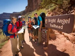 Hikers preparing at the Bright Angel Trailhead, Grand Canyon, with informational signs and the trail visible, illustrating a guide to parking and shuttles.