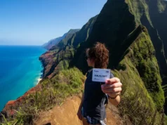 Kalalau Trail Permits: A Step-by-Step Strategy A hiker on a dramatic overlook of the Na Pali Coast with a printed Kalalau Trail permit in hand, symbolizing a successful permit strategy.