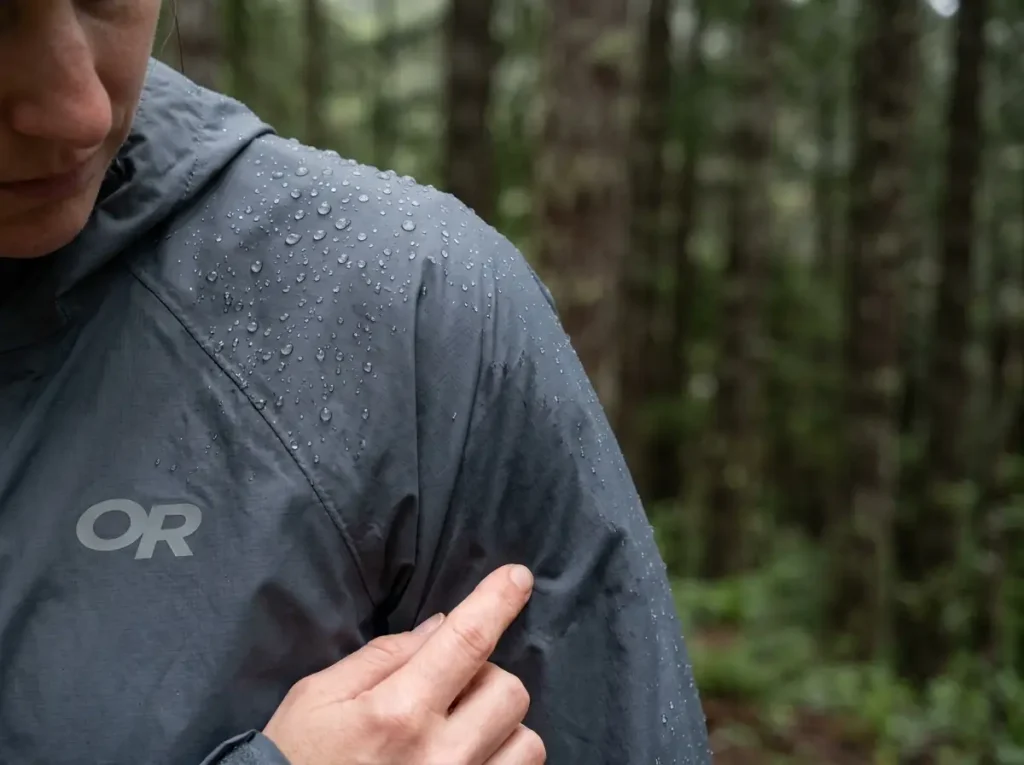 Water beading on one shoulder of a rain jacket and soaking into the other where the DWR has worn off