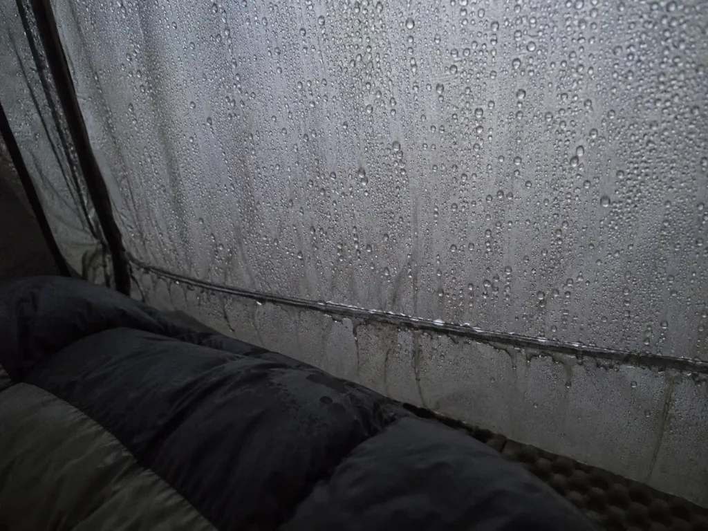 Condensation beaded on the inner wall of a truck bed tent on a cold grey morning