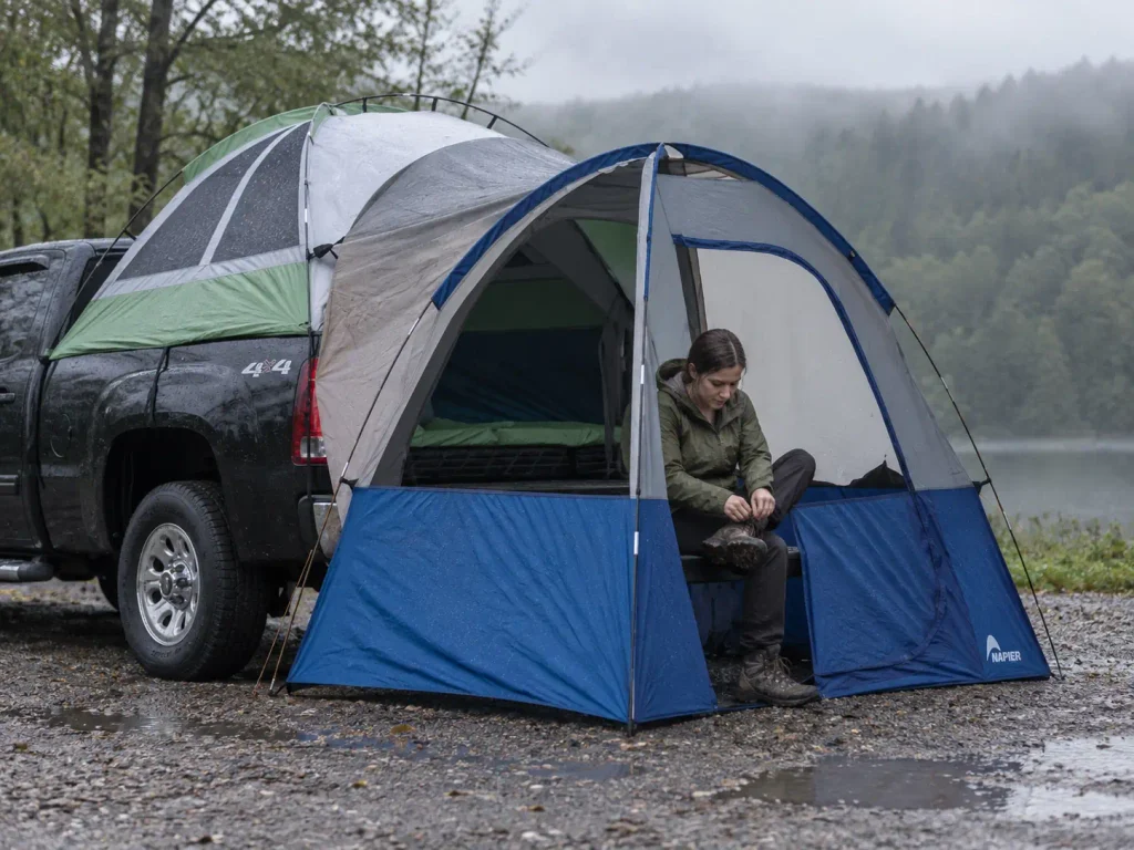 Napier Backroadz truck bed tent with its tailgate shelter pitched on a wet grey afternoon