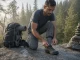 5 Good Trekking Shoes Compared Sole Stiffness Wins Hiker lacing good trekking shoes on a wet granite step before a long climb