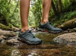 Hiker wearing versatile hiking and water shoes on a rocky trail with a forest and river backdrop.