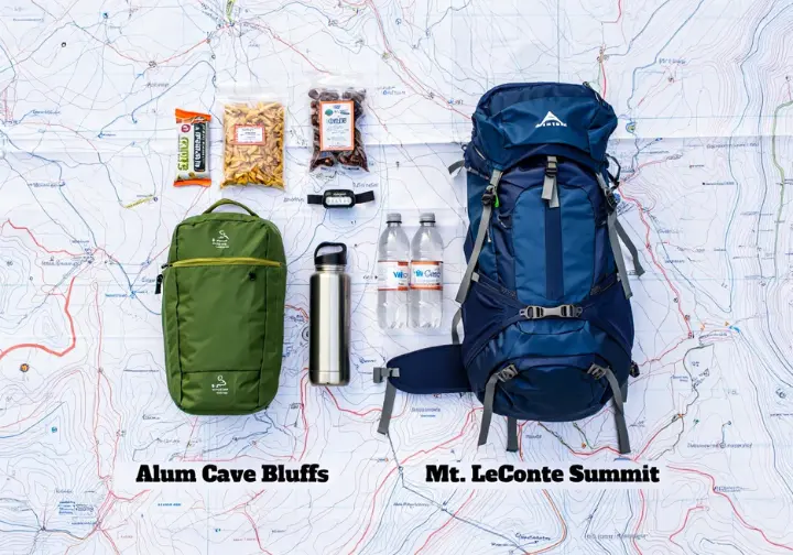 Flat lay comparison of hiking gear for a day hike to Alum Cave Bluffs vs. an overnight hike to Mt. LeConte, illustrating two hikes in one.