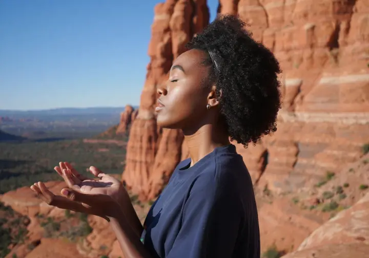 A person standing contemplatively on Bell Rock, representing the spiritual and energetic aspects of the Bell Rock vortex.