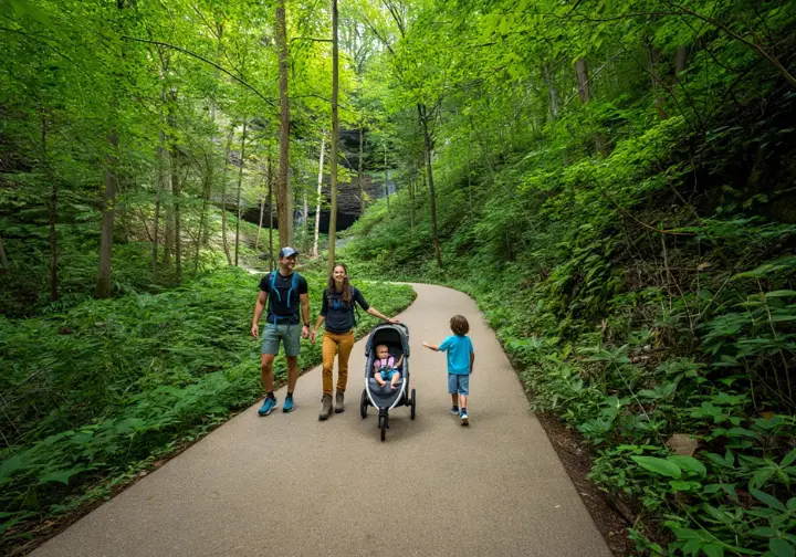 A family with a stroller walks on a newly paved, accessible Laurel Falls Trail in 2026, showcasing the future and expected improvements after rehabilitation.