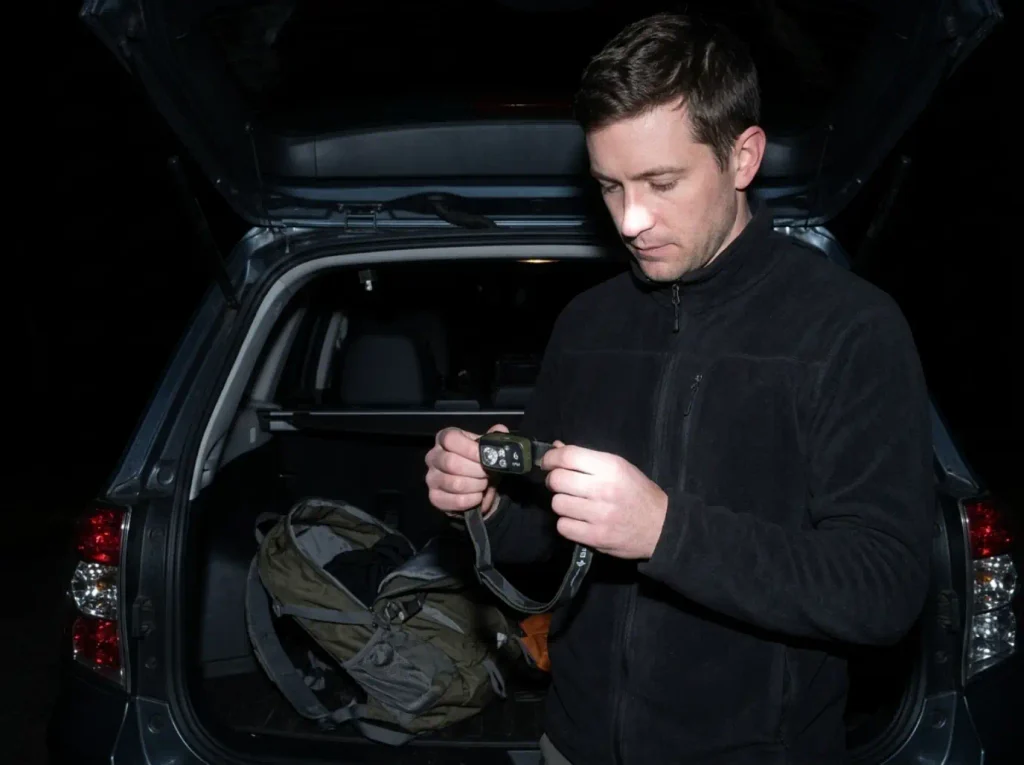 Hiker checking a headlamp before a dawn start on the Alum Cave Bluffs trail