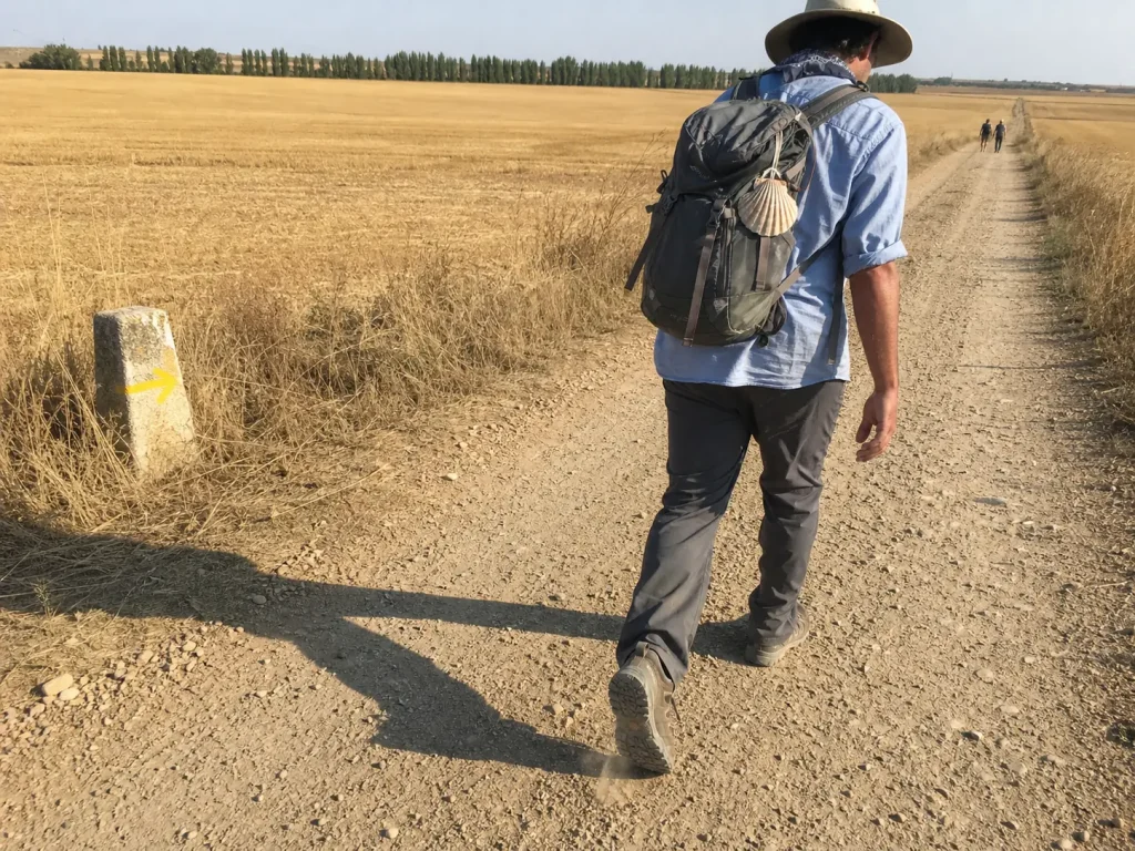 Trekker on the Camino de Santiago meseta in broken in low cut trekking shoes