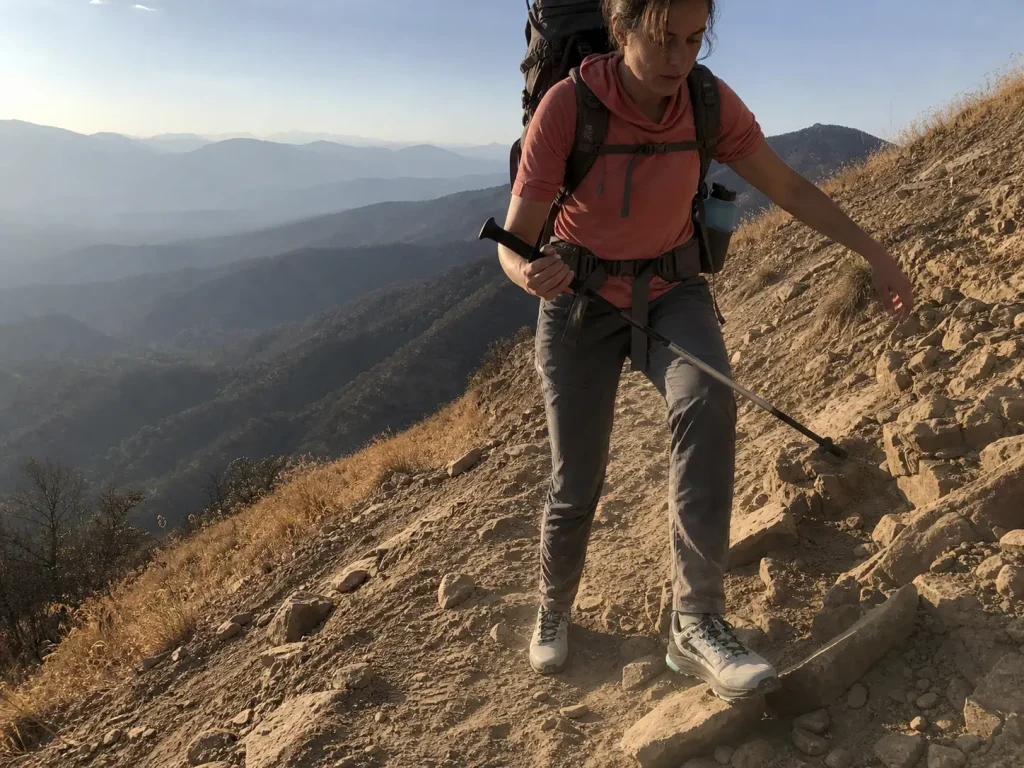 Tired hiker placing a foot carefully on loose rock late on a multi day trek