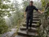 Bear Mountain Hike Difficulty Has Two Real Answers Hiker descending the stone steps on the Bear Mountain hike in New York on an overcast morning