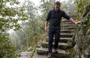 Bear Mountain Hike Difficulty Has Two Real Answers Hiker descending the stone steps on the Bear Mountain hike in New York on an overcast morning