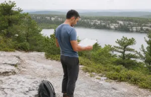 Minnewaska State Park Has 3 Areas Here’s Which to Hike Hiker checking a trail map where the carriage road splits above Lake Minnewaska State Park