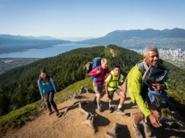A diverse group of hikers on a mountain trail, overlooking Vancouver city and ocean, representing the best hikes for every skill level.