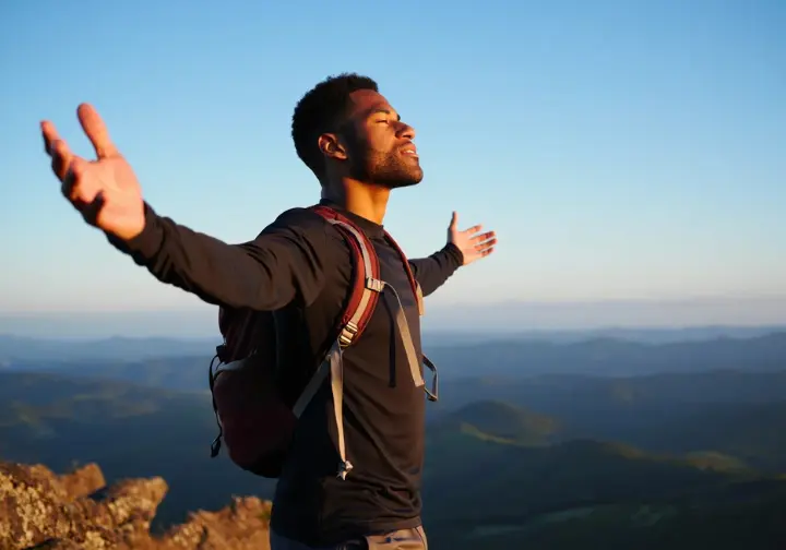 A person at a scenic overlook, deeply inhaling, illustrating the profound connection to nature and personal fulfillment found in hiking.