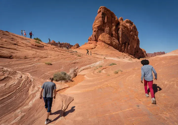 Diverse hikers exploring various terrains in Valley of Fire State Park, illustrating a comprehensive guide to its trails.