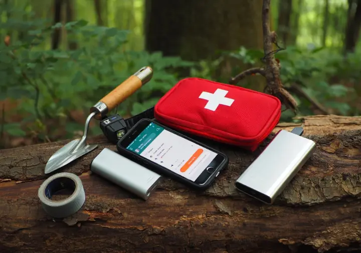 Essential support, safety, and hygiene items like a phone, first-aid kit, and headlamp, illustrating critical gear for a thru-hiking gear list.