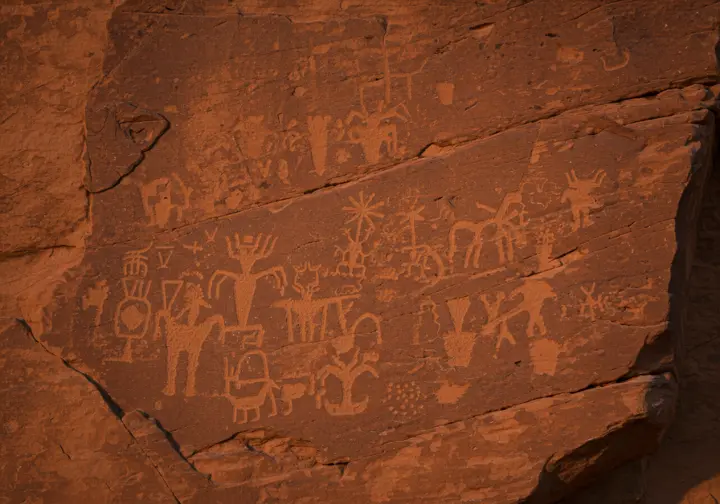 Close-up photograph of ancient petroglyphs on red sandstone in Valley of Fire.