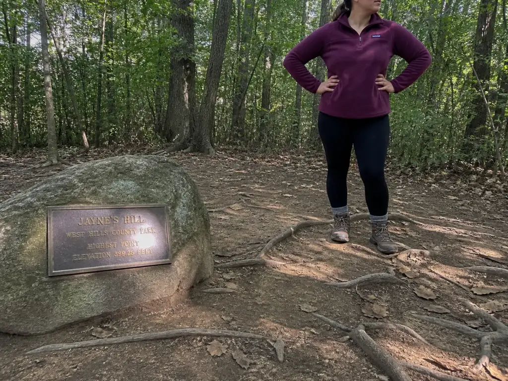 The summit marker and worn dirt trail at Jayne's Hill, the highest natural point for hiking on Long Island.