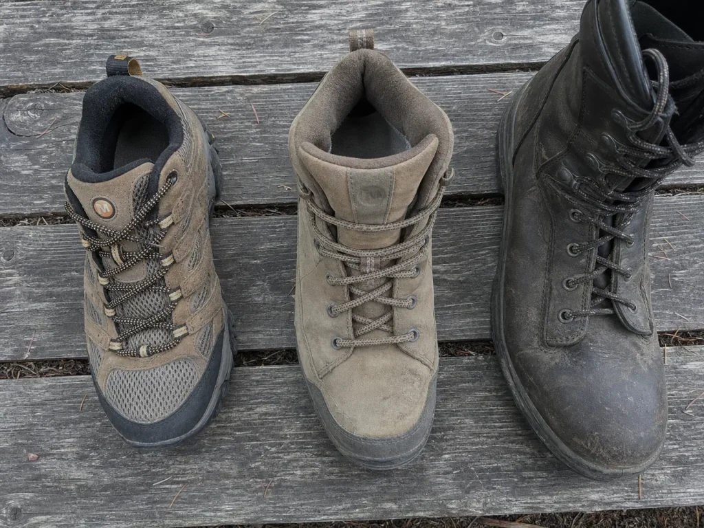 Low-cut hiking shoe beside a mid-cut and high-cut boot showing collar height difference