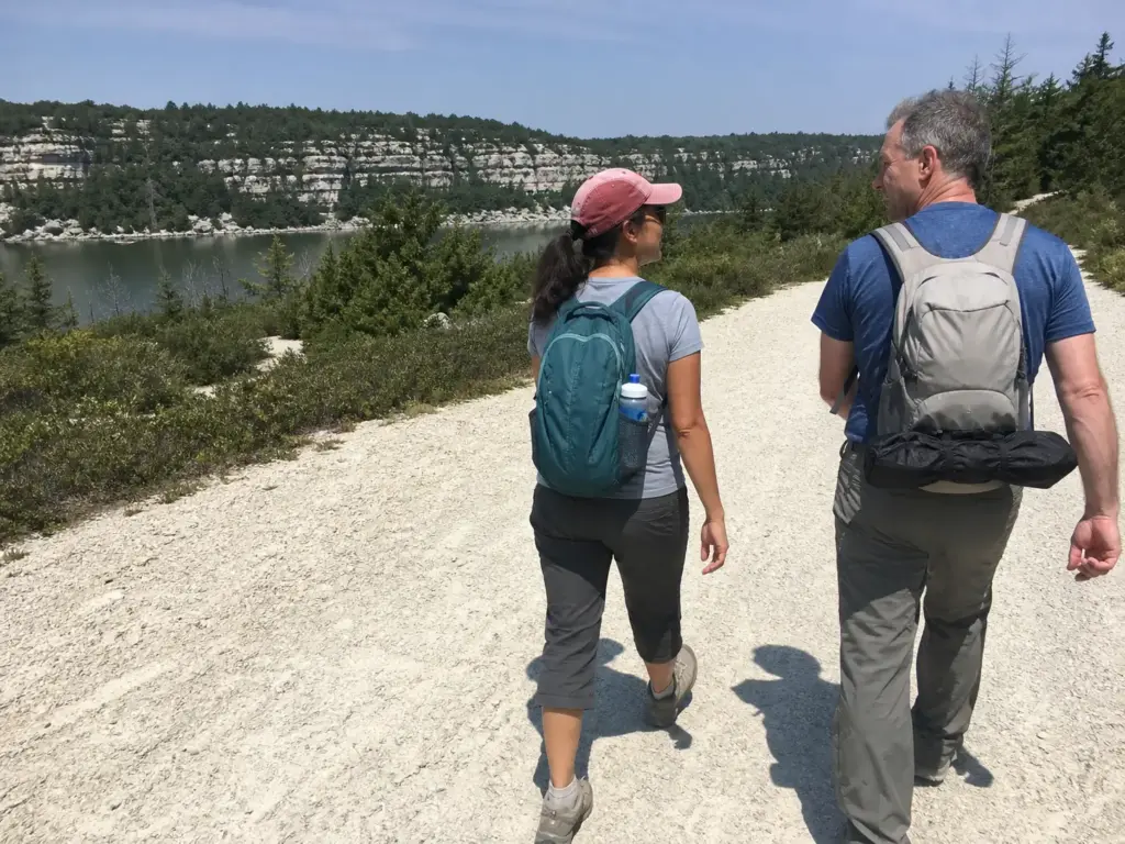 Two hikers on the wide crushed-stone carriage road loop around Lake Minnewaska