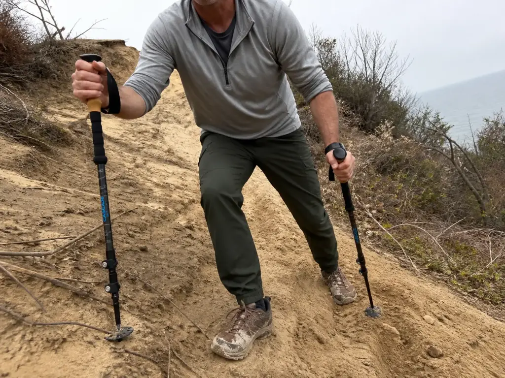 Hiker using trekking poles on the steep sandy bluff climb at Sunken Meadow, a North Shore Long Island hike.
